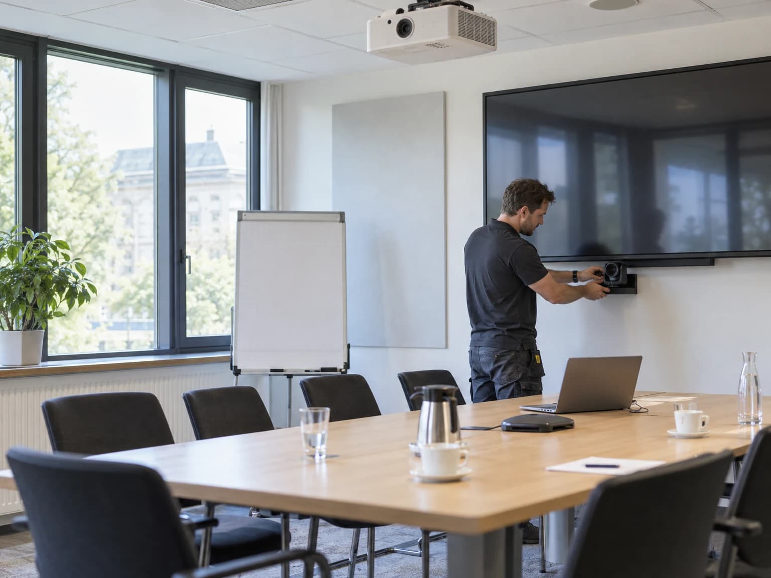Medientechniker richtet Display und Konferenzkamera in einem Besprechungsraum ein