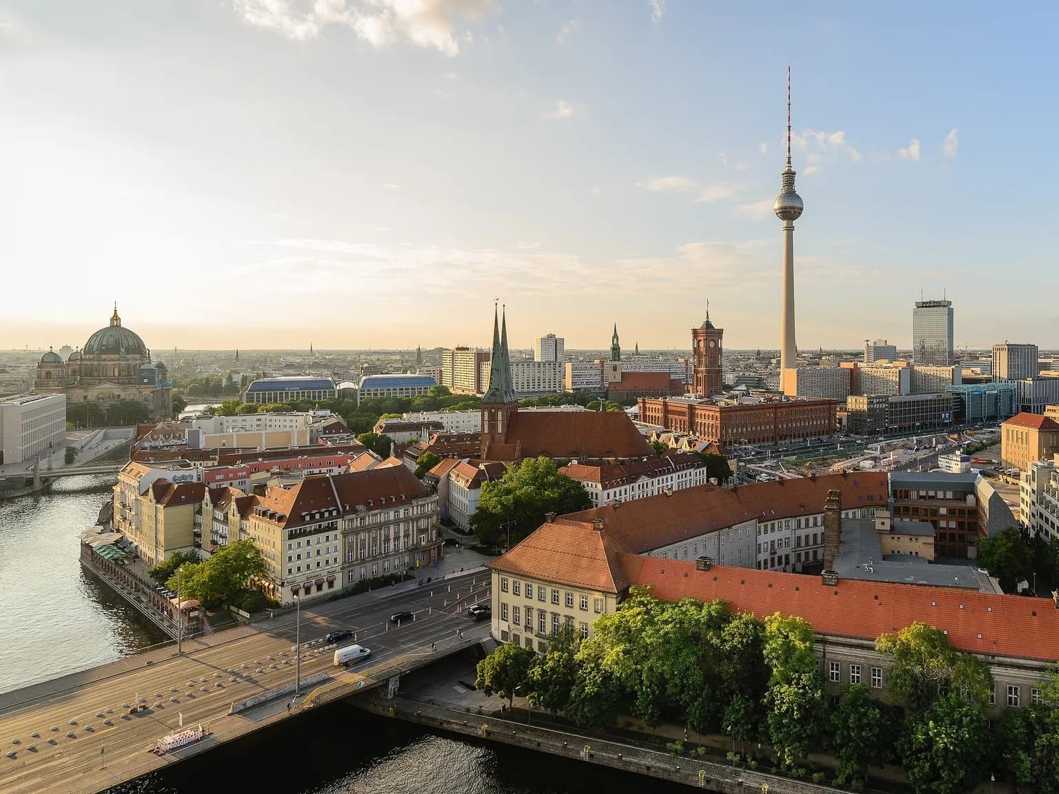 Blick von der Fischerinsel über die Spree auf Berlin-Mitte mit Berliner Dom, Nikolaikirche, Rotem Rathaus und Fernsehturm im Abendlicht.